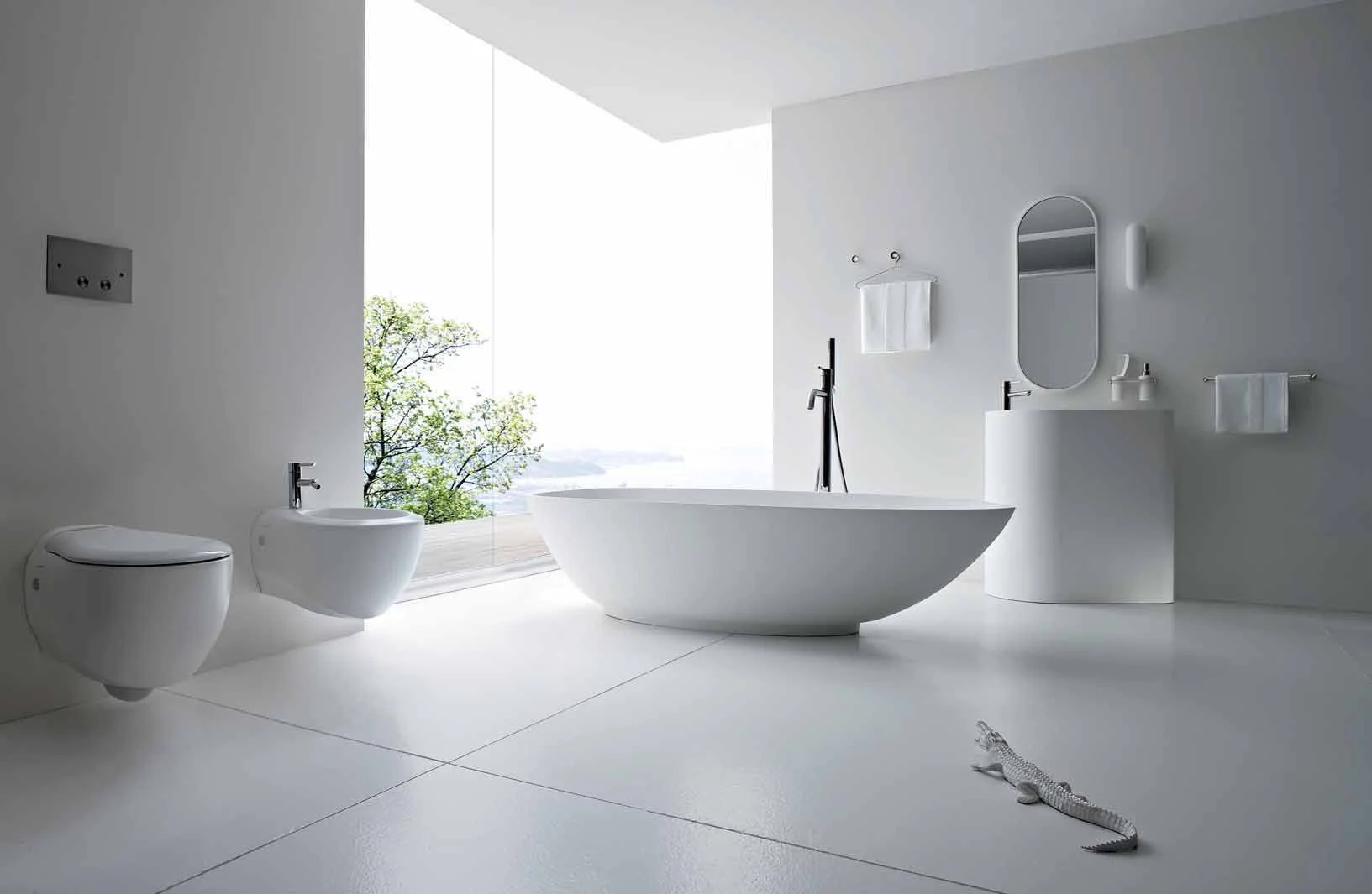 Freestanding bathtub beside a large window